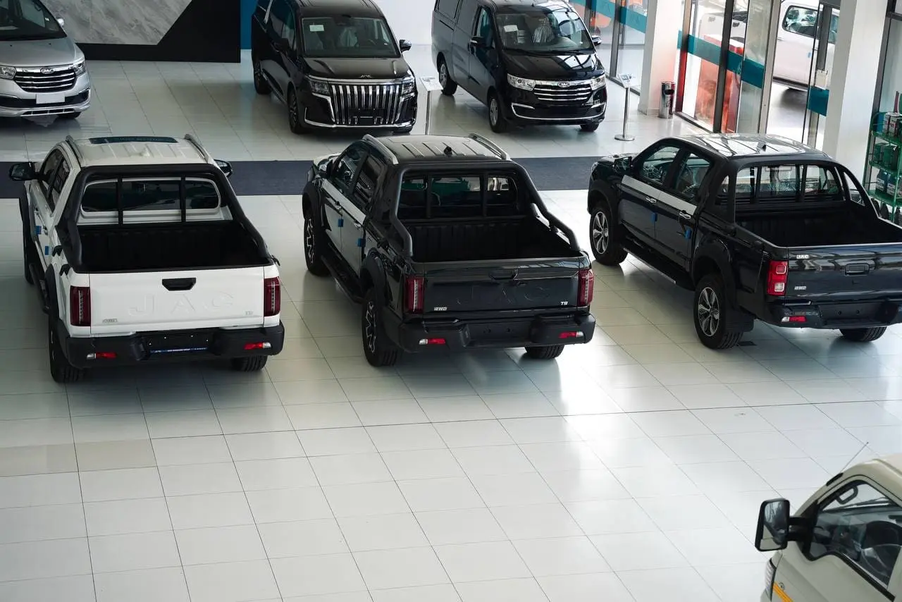 modern luxury JAC dealership interior panoramic view multiple vehicles premium showroom lighting